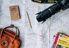 flat lay photography of camera, book, and bag