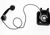 photo of black rotary phone against white background